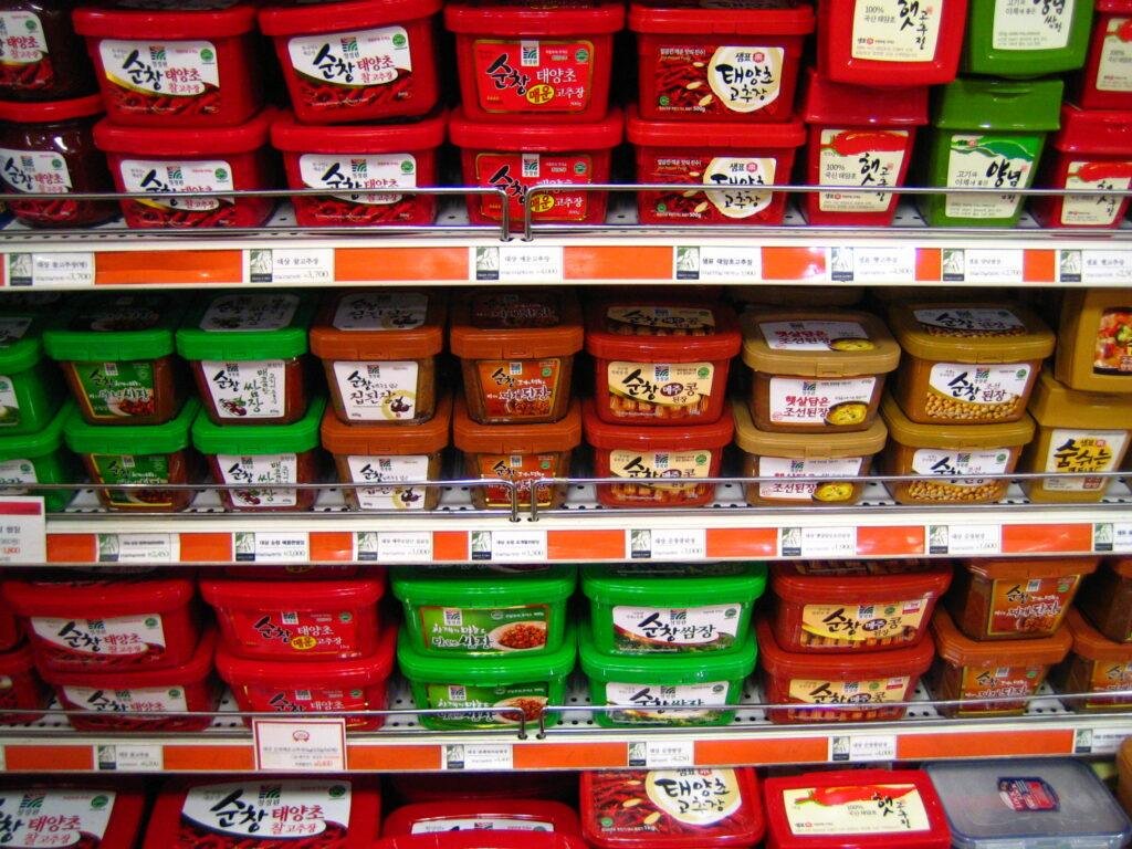 Tubs of gochujang stacked on a supermarket shelf in Seoul