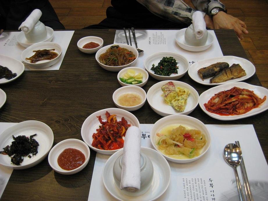 A spread of small Korean banchan side dishes in bowls on a table