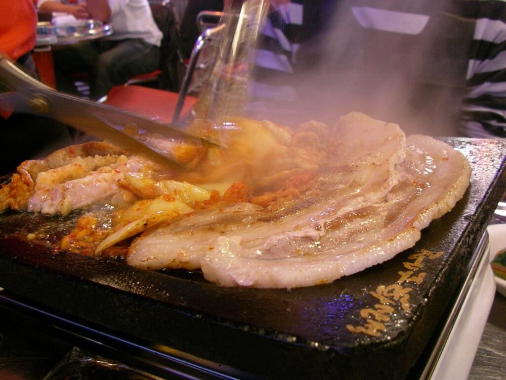 Grilled samgyeopsal, Korean pork belly, cooking on a tabletop grill